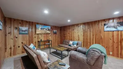 a living room with wooden walls and a couch and a table at Spacious Arvada Family Home with King Beds and Office in Arvada