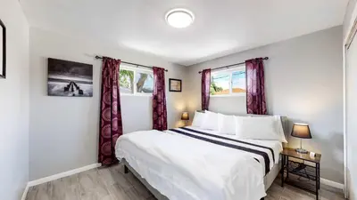 a bedroom with a white bed and two windows at Bright & Spacious Upper Unit with Two Bedrooms in Denver in Denver