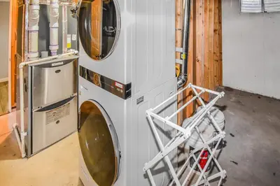 a washer and dryer sitting in a garage at Sunny Family Home in Denver with huge yard and hot tub in Denver