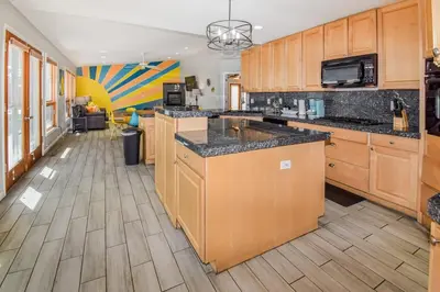 a kitchen with wooden cabinets and a counter top at Sunny Family Home in Denver with huge yard and hot tub in Denver