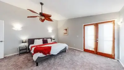 a bedroom with a bed and a ceiling fan at Sunny Family Home in Denver with huge yard and hot tub in Denver