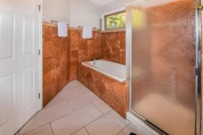 a bathroom with a shower and a tub at Sunny Family Home in Denver with huge yard and hot tub in Denver