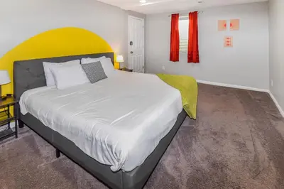 a bedroom with a large bed with a yellow headboard at Sunny Family Home in Denver with huge yard and hot tub in Denver