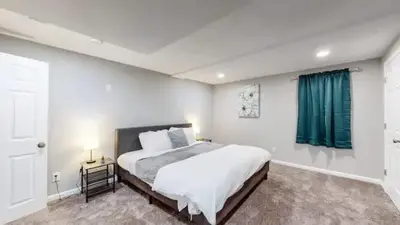 a bedroom with a large bed with a green curtain at Sunny Family Home in Denver with huge yard and hot tub in Denver