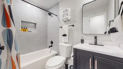 a white bathroom with a sink and a toilet and a tub at Spacious Family Retreat in Denver in Denver