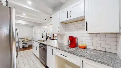 a kitchen with white cabinets and a counter top at Stunning Upper Family Unit with King Beds & Yard in Denver