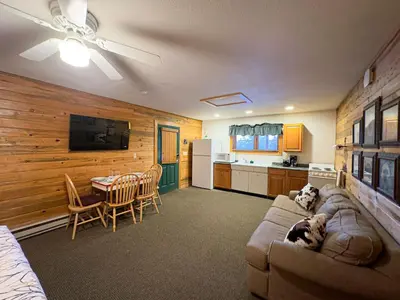a living room with a couch and a table and a kitchen at Kinnikinnick Retreat Steps from the Lake and Board walk, 5 min drive to RMNP. in Grand Lake