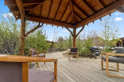 a wooden deck with chairs and a picnic table at Kinnikinnick Retreat Steps from the Lake and Board walk, 5 min drive to RMNP. in Grand Lake