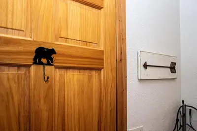 a black cat sitting on top of a wooden door at Kinnikinnick Retreat Steps from the Lake and Board walk, 5 min drive to RMNP. in Grand Lake