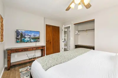 a bedroom with a bed and a flat screen tv at Old Town Basecamp 6 Blocks to Old Town Square in Fort Collins
