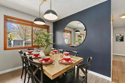 a dining room with a table and chairs and a mirror at Old Town Basecamp 6 Blocks to Old Town Square in Fort Collins