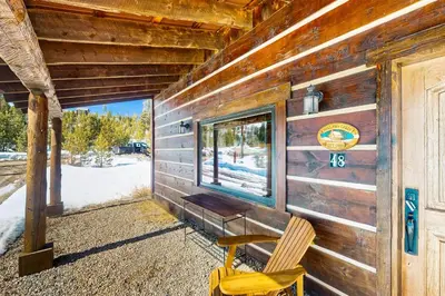 a wooden cabin with a bench and a window at Shadow Mountain Marina in Grand Lake