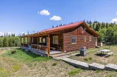 a log cabin in a field with a picnic table at Randalman House in Walden
