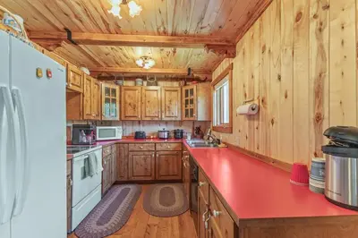 a kitchen with wooden cabinets and a red counter top at Randalman House in Walden