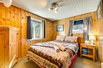 a bedroom with a bed in a wooden room at Private Hot Tub and Deck Riverfront Escape in Drake in Drake
