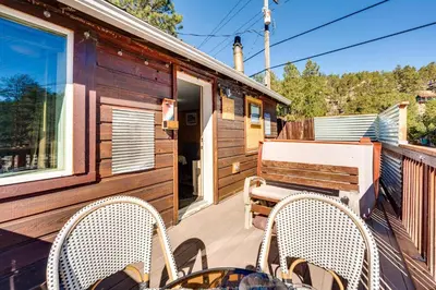 a deck with two chairs and a bench at Private Hot Tub and Deck Riverfront Escape in Drake in Drake