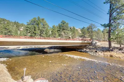 a bridge over a river next to a river at Private Hot Tub and Deck Riverfront Escape in Drake in Drake