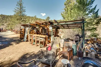 a group of chairs and tables and a wooden building at Private Hot Tub and Deck Riverfront Escape in Drake in Drake