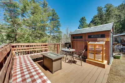 a wooden deck with a table and a kitchen on it at 4 Mi to Downtown Estes Park Nature Retreat in Drake