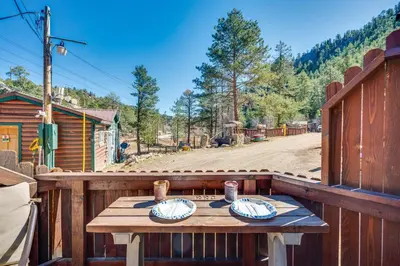 a wooden table on a wooden deck with plates on it at 8 Mi to Rocky Mountain Natl Park Serene Escape in Drake