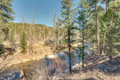 a river in a forest with trees and a creek at 8 Mi to Rocky Mountain Natl Park Serene Escape in Drake