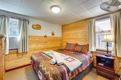 a bedroom with a bed and wooden walls at 8 Mi to Rocky Mountain Natl Park Serene Escape in Drake