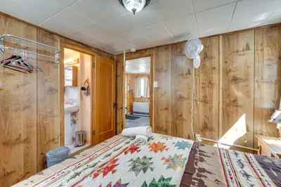 a bedroom with wooden walls and a large bed at Private Hot Tub and Deck Romantic Getaway in Drake in Drake