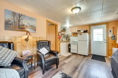 a living room with two chairs and a refrigerator at Private Hot Tub and Deck Romantic Getaway in Drake in Drake