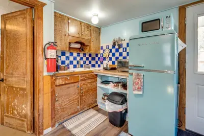 an old refrigerator in a kitchen with wooden cabinets at Fish, Hike and Unwind Drake Cabin with Hot Tub! in Drake