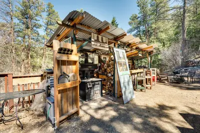 a wooden building with a stove in a yard at Fish, Hike and Unwind Drake Cabin with Hot Tub! in Drake