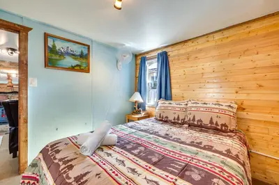 a bedroom with a bed and a wooden wall at Fish, Hike and Unwind Drake Cabin with Hot Tub! in Drake