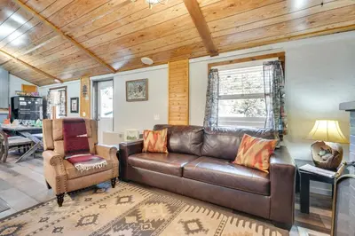 a living room with a leather couch and a chair at Private Hot Tub and Fishing On-Site Cabin in Drake in Drake