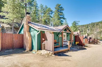 a small green shack with a fence and trees at Private Hot Tub and Fishing On-Site Cabin in Drake in Drake