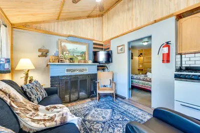 a living room with a couch and a fireplace at 4 Mi to Estes Park Riverfront Cabin with Hot Tub! in Drake