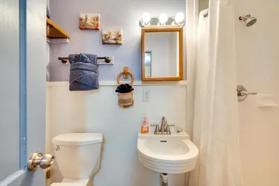 a bathroom with a toilet and a sink and a mirror at 4 Mi to Estes Park Riverfront Cabin with Hot Tub! in Drake
