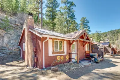 a small red house with a chimney on top at 4 Mi to Estes Park Riverfront Cabin with Hot Tub! in Drake