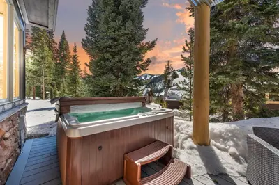 a hot tub on a deck in the snow at 102 Mountain Lodge Way in Winter Park