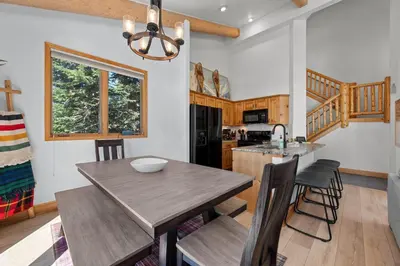 a kitchen and dining room with a wooden table and chairs at 102 Mountain Lodge Way in Winter Park