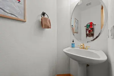 a white bathroom with a sink and a mirror at 102 Mountain Lodge Way in Winter Park