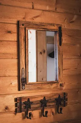 a mirror on the side of a wooden wall at Elk Run cabin steps to lake, In town, 5 min to RMNP in Grand Lake