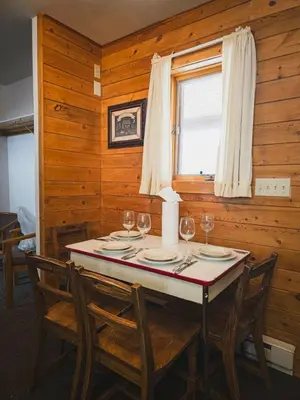 a dining room with a table with wine glasses at Elk Run cabin steps to lake, In town, 5 min to RMNP in Grand Lake