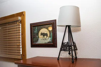a lamp on a table next to a painting of a camel at Hummingbird Heaven Cozy Cabin 1 Block to Lake, located in Town in Grand Lake