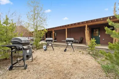 a backyard with a barbecue grill and a house at Hummingbird Heaven Cozy Cabin 1 Block to Lake, located in Town in Grand Lake
