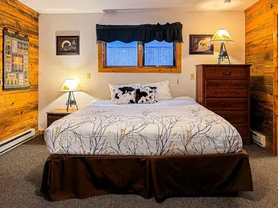 a bedroom with a bed and a dresser and a window at Hummingbird Heaven Cozy Cabin 1 Block to Lake, located in Town in Grand Lake