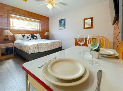 a room with a table with plates and wine glasses at Columbine Charming Cabin, 1 block from the lake, in town, 5 min to RMNP in Grand Lake