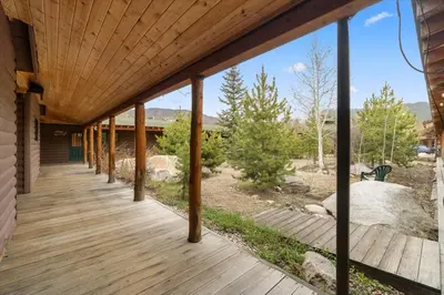 a wooden porch of a house with a deck at Columbine Charming Cabin, 1 block from the lake, in town, 5 min to RMNP in Grand Lake