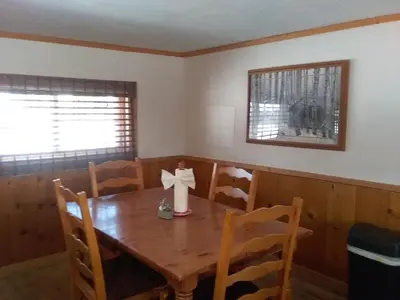 a dining room with a wooden table with a bow on it at Colorado Cabin Adventure in Grand Lake