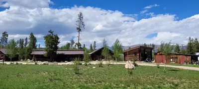 a group of buildings in a field next to a grass field at Colorado Cabin Adventure in Grand Lake