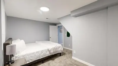 a white bedroom with a bed in a room at Cozy Lower Affordable Apartment great for families in Arvada