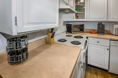 a kitchen with a white stove and a microwave at Cozy Mountain-Inspired Lower Unit in Denver in Denver